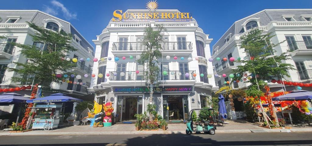 a white building with a sign on top of it at SUNRISE Hotel Bạc Liêu in Bạc Liêu