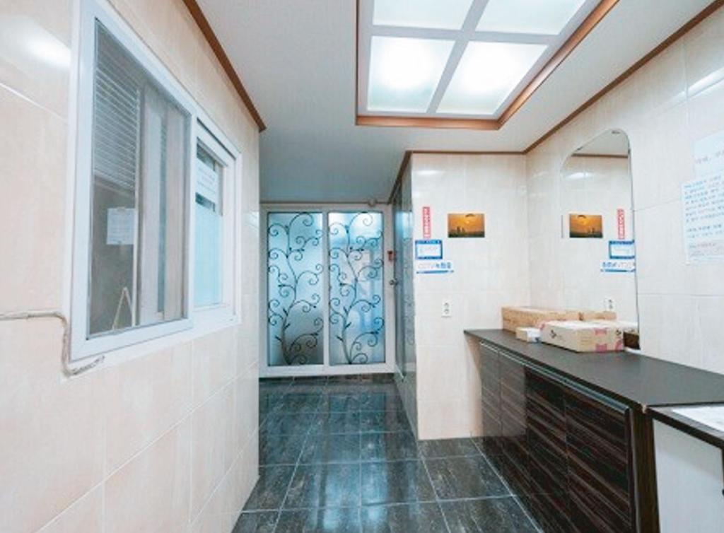 a bathroom with a sink and a door with a window at NineRoD - Private bathroom & Shower in Seoul