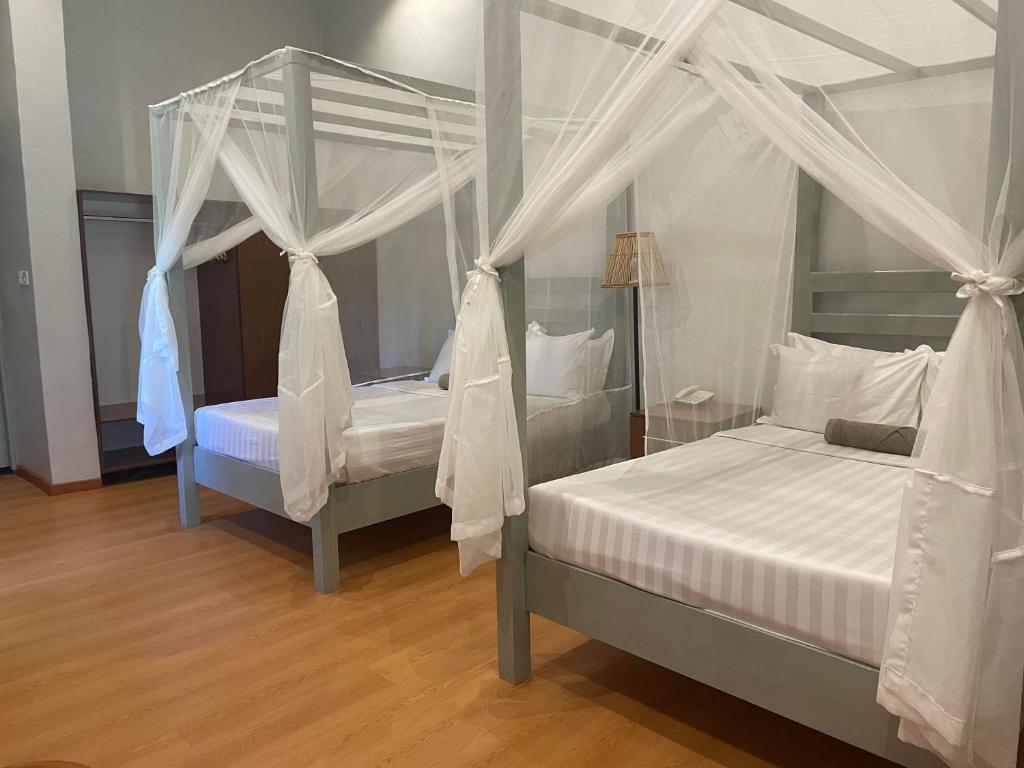 1 dormitorio con 2 camas con mosquiteras en Kara O Mula Mulanje, en Mulanje