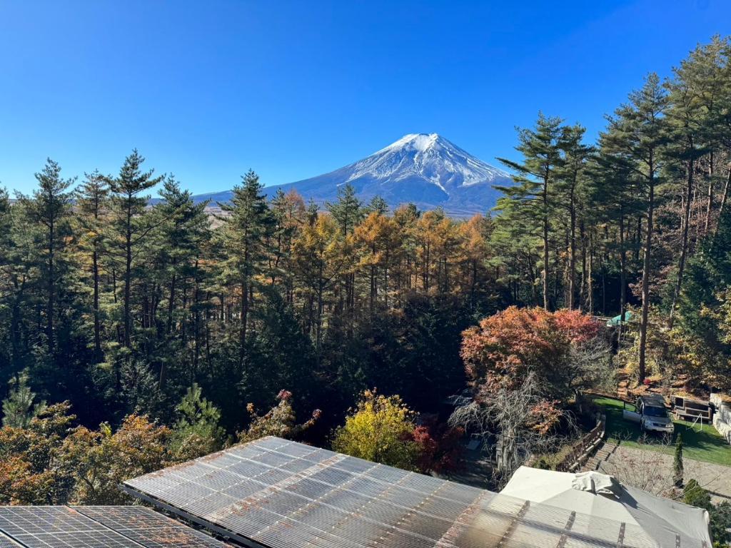 uma montanha à distância com painéis solares em primeiro plano em Altitude -アルティチュード-939 富士山の麓グランピング em Fujiyoshida