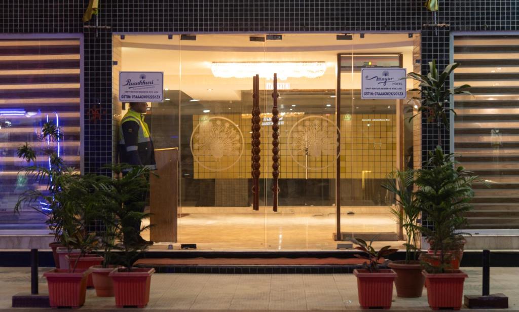 Mayur Hotel في نيودلهي: واجهة متجر مع نباتات الفخار أمام متجر