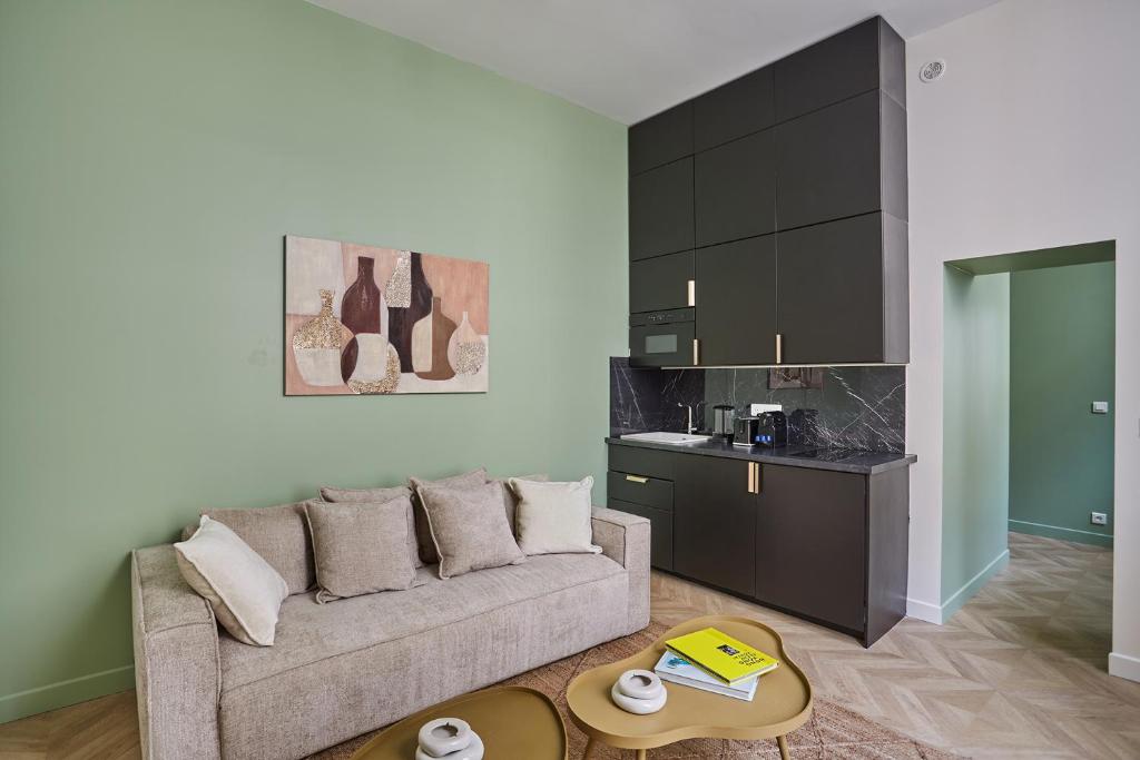 un salon avec un canapé et une cuisine dans l'établissement Apartment Saint Germain des prés by Studio prestige, à Paris