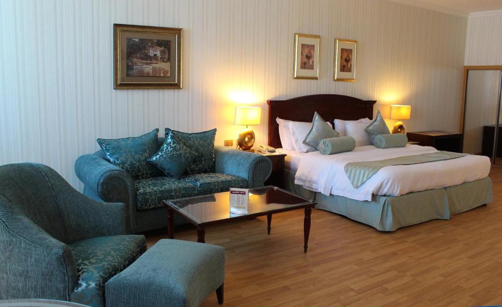 um quarto de hotel com uma cama e duas cadeiras em Swiss International Al Hamra Hotel em Dammam