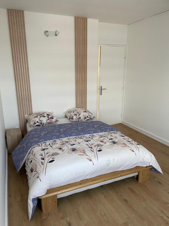 ein Schlafzimmer mit einem Bett mit einem Holzrahmen in der Unterkunft Coliving - Chambre blanche in Sarcelles