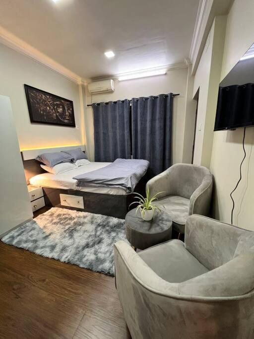 a bedroom with a bed and a couch and chairs at GSquare Serviced Appartment in Burhānilkantha