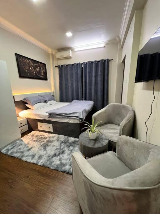 una camera da letto con un letto, un divano e delle sedie di GSquare Serviced Appartment a Burhānilkantha