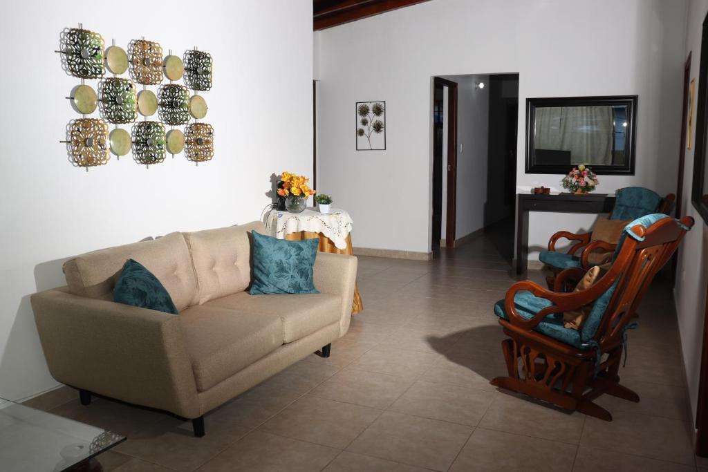 een woonkamer met een bank en een stoel bij Medellin My Home in Medellín