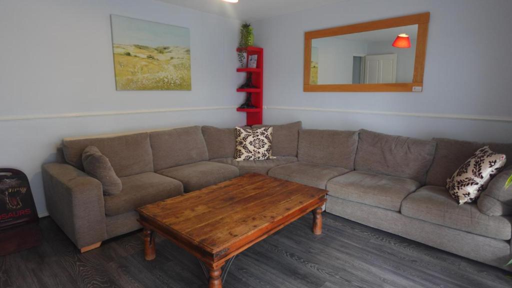 a living room with a couch and a coffee table at Chelsea House-Huku Kwetu Dunstable-3 Bedroom House - Suitable & Affordable -Business Travellers - Group Accommodation - Comfy, Spacious with Lovely Garden Views in Houghton Regis