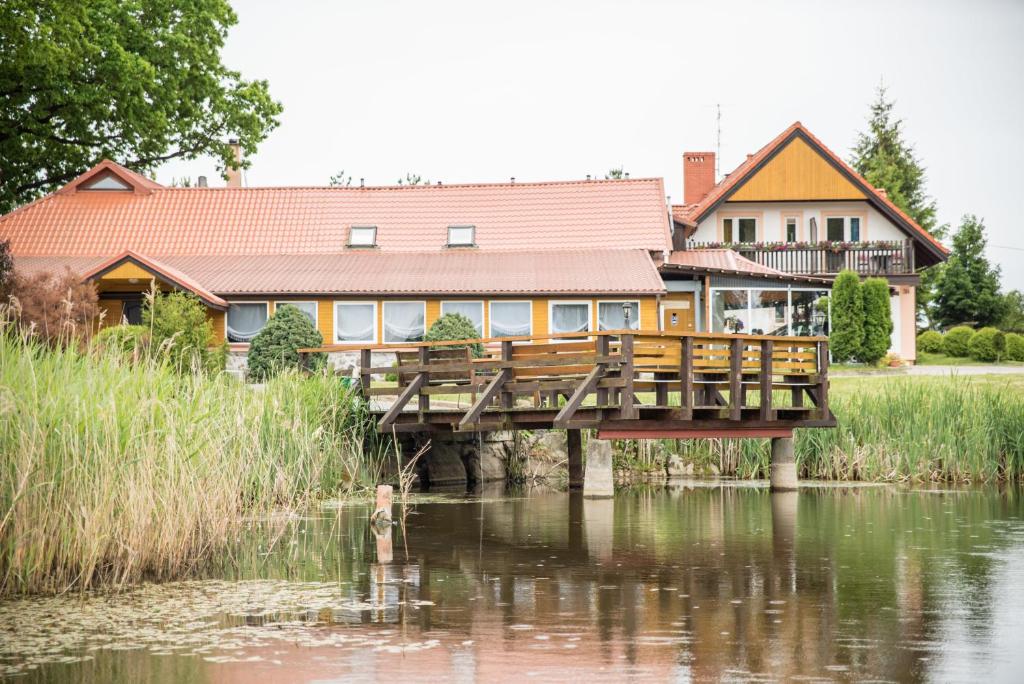 una casa en un puente sobre un cuerpo de agua en Gościniec Czapla, en Dywity