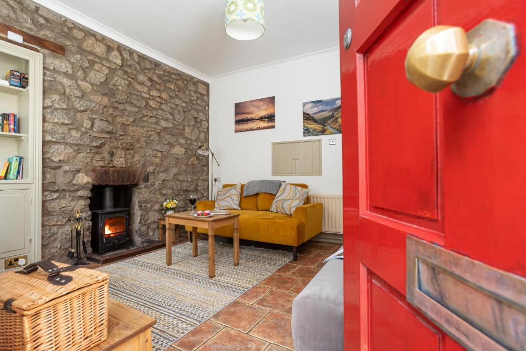 a living room with a couch and a fireplace at Marian Cottage in Ingleton