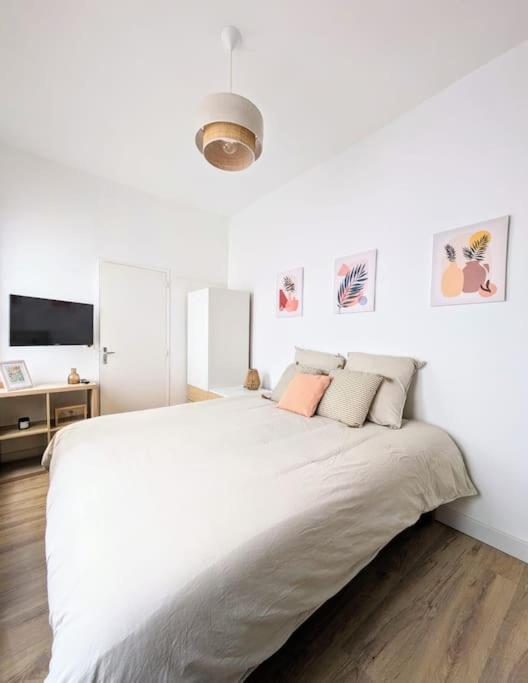 une chambre blanche avec un grand lit blanc avec des oreillers dans l'établissement Rouen Centre historique, à Rouen