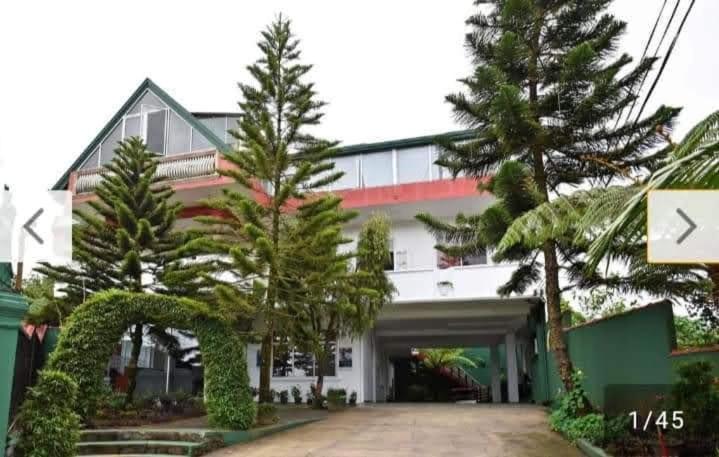 a large white building with trees in front of it at American Star Hotel- Nuwaraeliya in Nuwara Eliya
