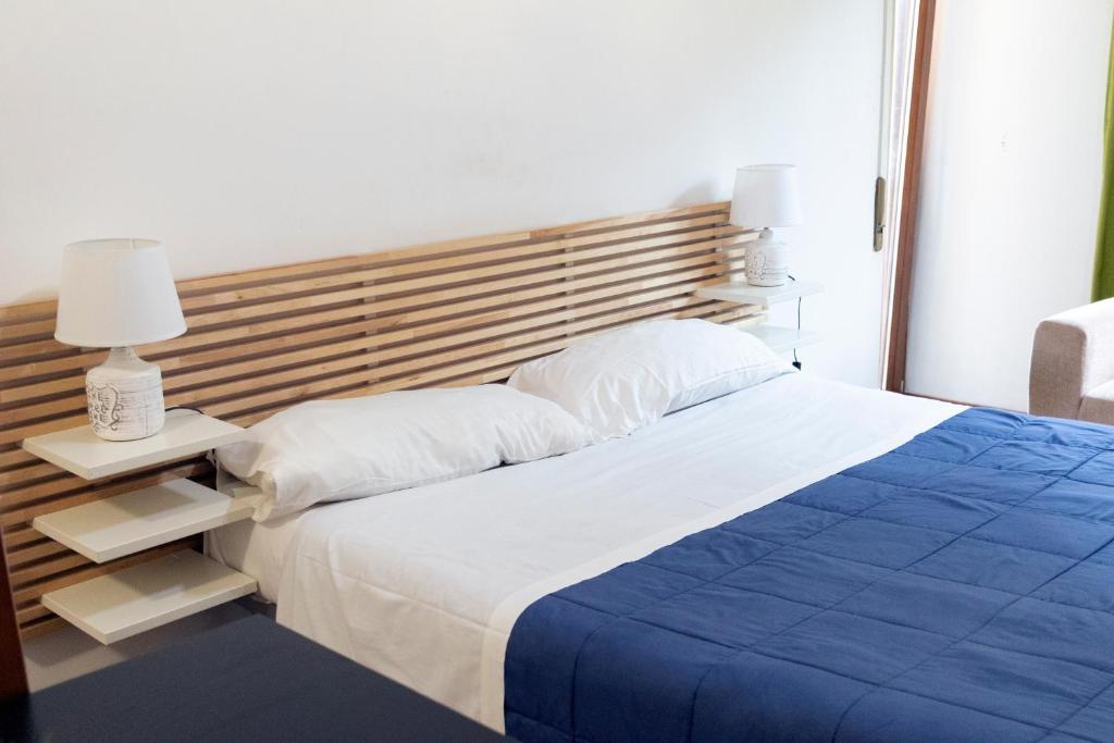 a bedroom with a large bed with a wooden headboard at La Vittoria in Lido di Ostia