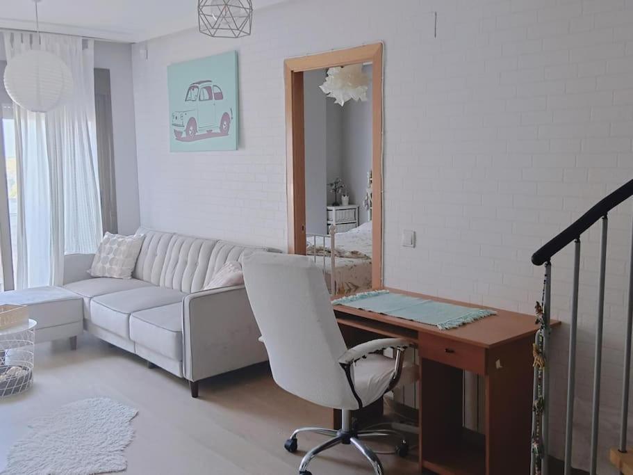 een woonkamer met een witte bank en een bureau bij Rincón de Relax in Ocaña