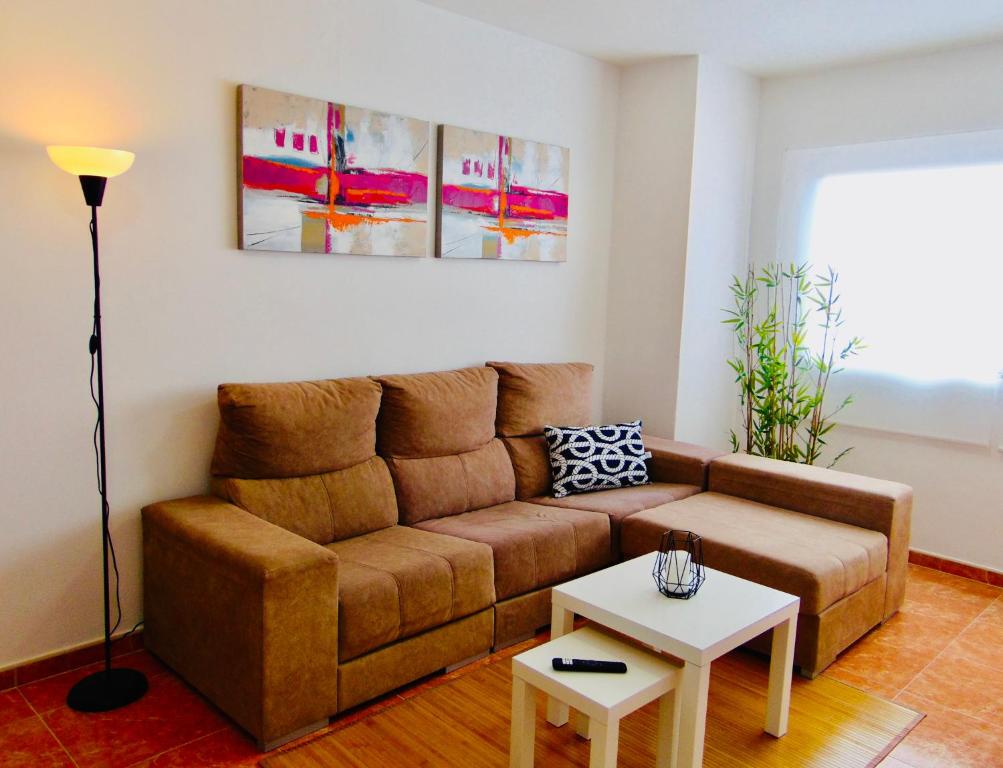 - un salon avec un canapé brun et une table dans l'établissement Playa Chica House 2 Fuerteventura, à Puerto del Rosario