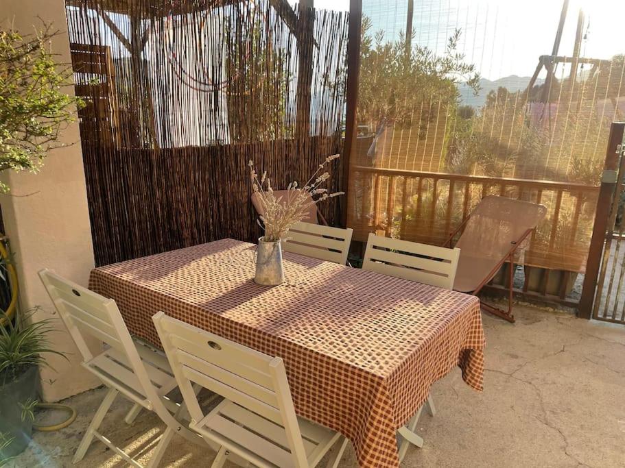 una mesa con sillas y un jarrón con flores. en Maison de village cosy et chaleureuse, en Tavera