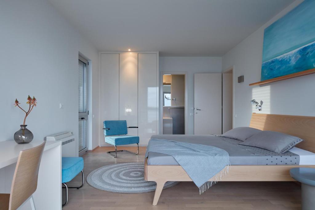 a bedroom with a bed and a blue chair at Villa Roca in Vis