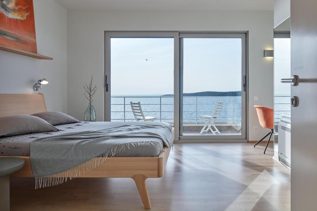 a bedroom with a bed and a view of the ocean at Villa Roca in Vis