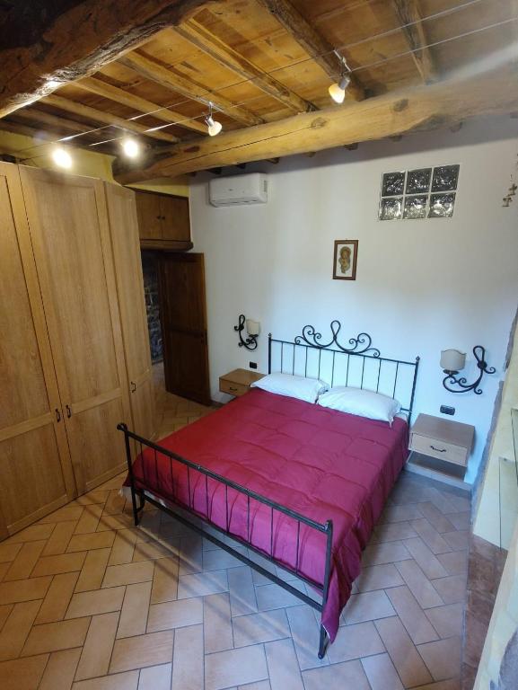 a bedroom with a large red bed in a room at Dimora de' Canulei in Bolsena