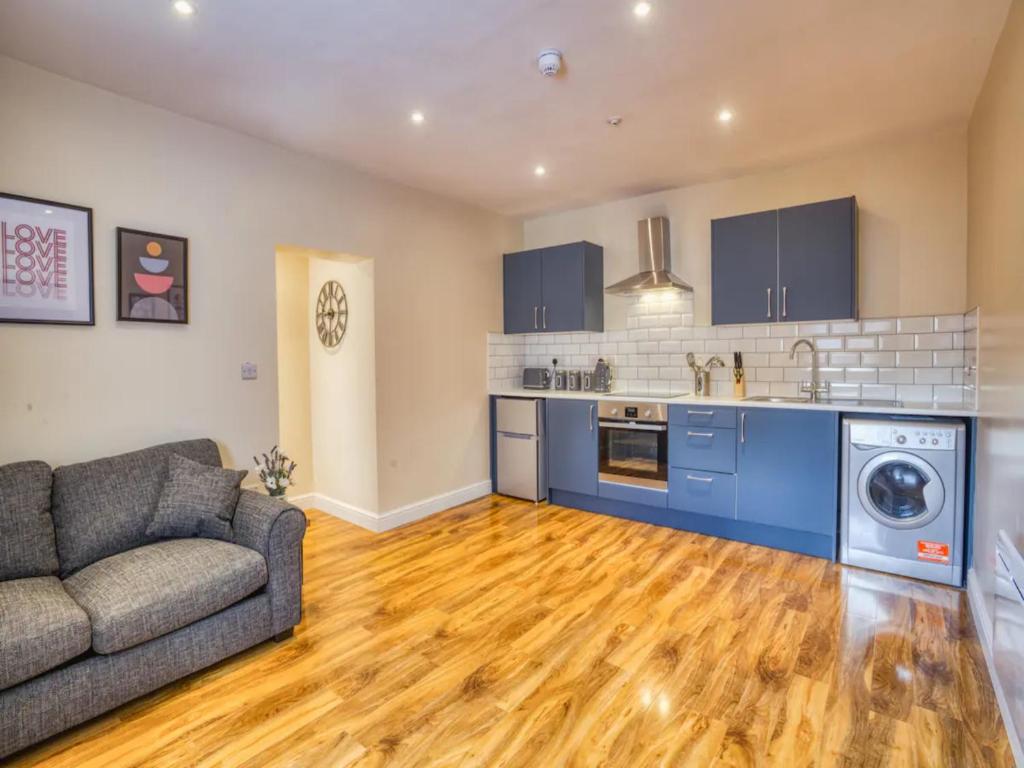a living room with a couch and a kitchen at Pass the Keys Spacious Flat in the City Centre in Lincoln