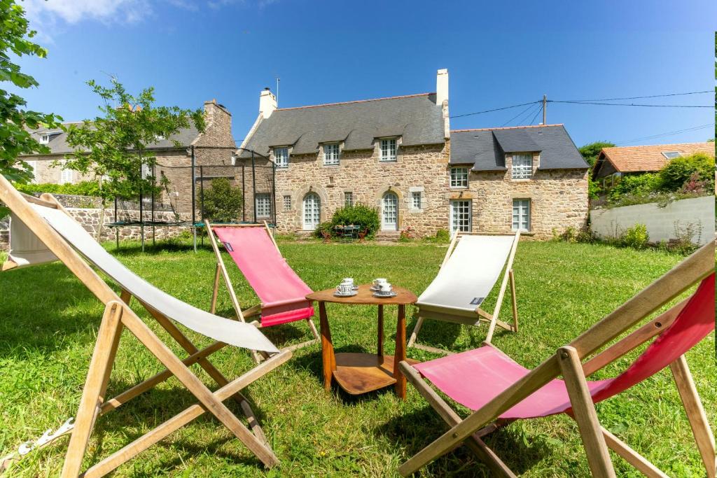 three chairs and a table in front of a house at La Ville Bourse - Charmante villa à Erquy in Erquy