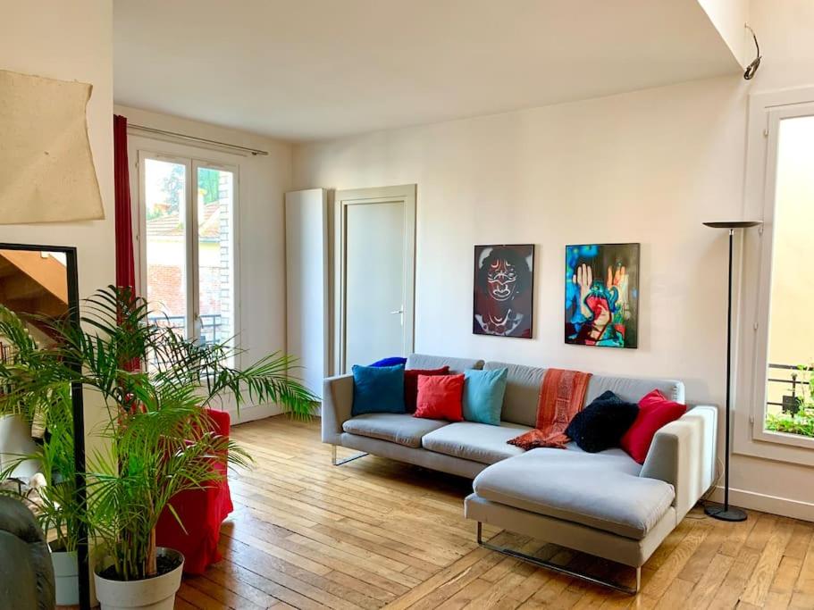 - un salon avec un canapé et des oreillers colorés dans l'établissement Duplex avec Terrasse proche JO, à Le Pré-Saint-Gervais