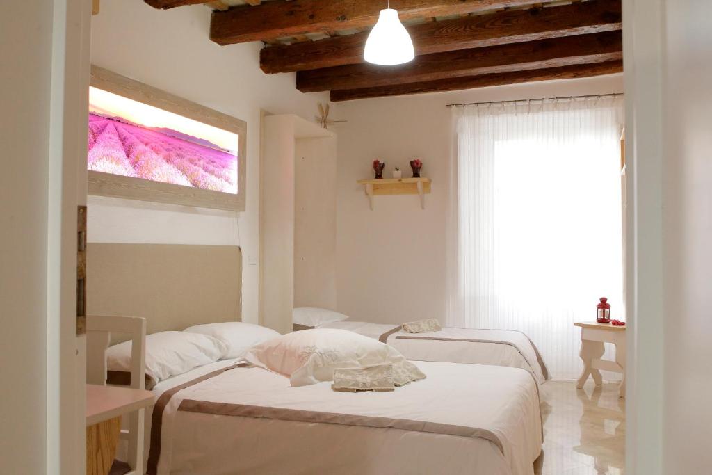 a white room with a bed and a window at Appartamento Alla Corte dei Misteri in Trapani
