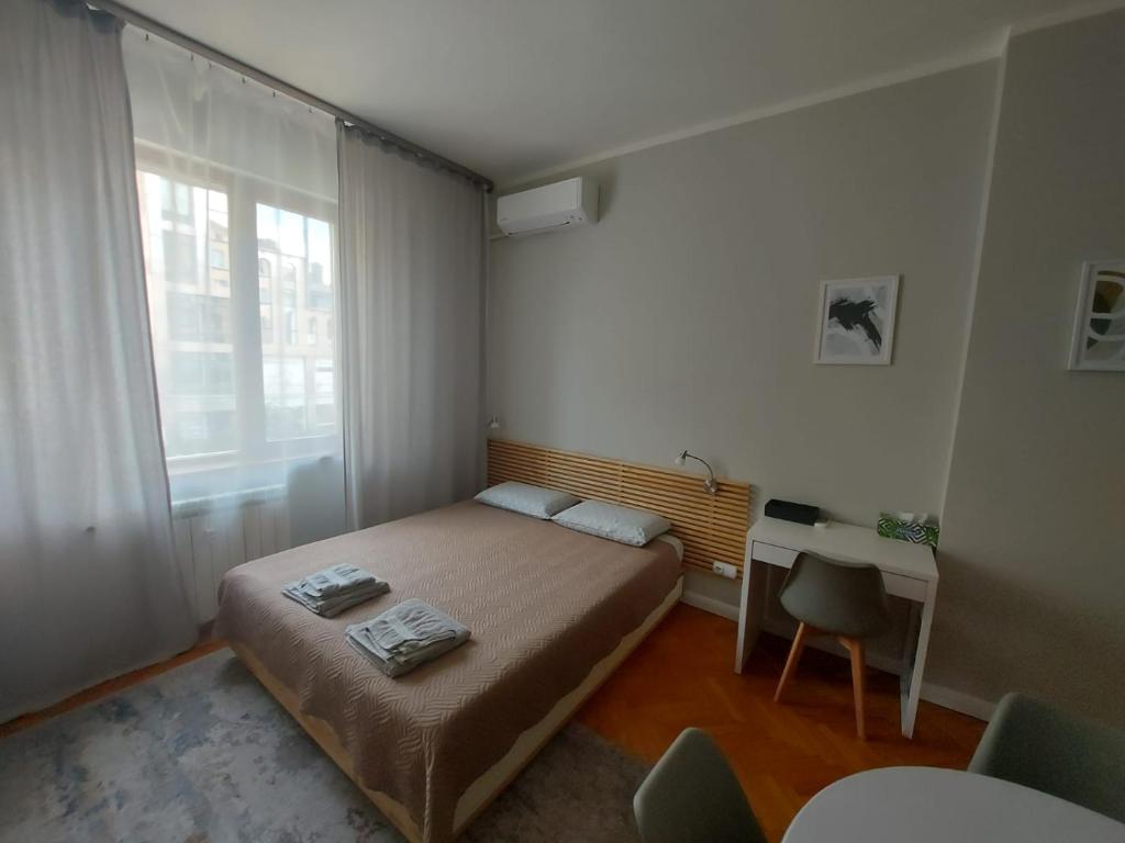 una piccola camera da letto con un letto e una scrivania di Studio 72 a Sofia