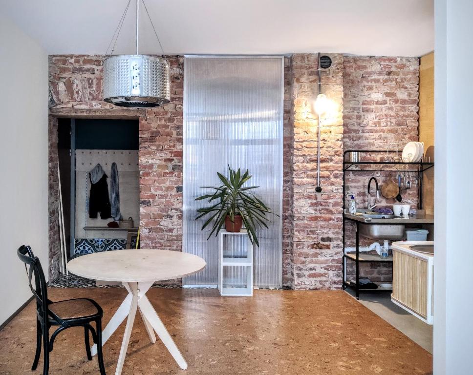 a room with a table and a brick wall at Unique design, hype location! in Rīga
