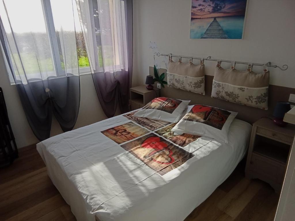 1 dormitorio con 1 cama con sábanas y almohadas blancas en gite repos et tranquillité P, en Cayeux-sur-Mer
