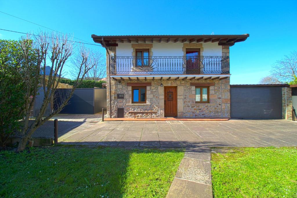 a brick house with a balcony on top of it at La Senda Escogida in Torrelavega