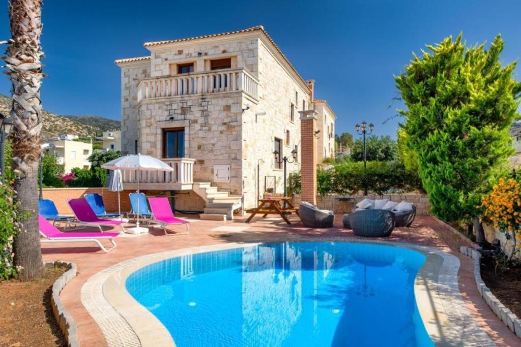 a villa with a swimming pool in front of a house at Summer Dream Villas in Hersonissos