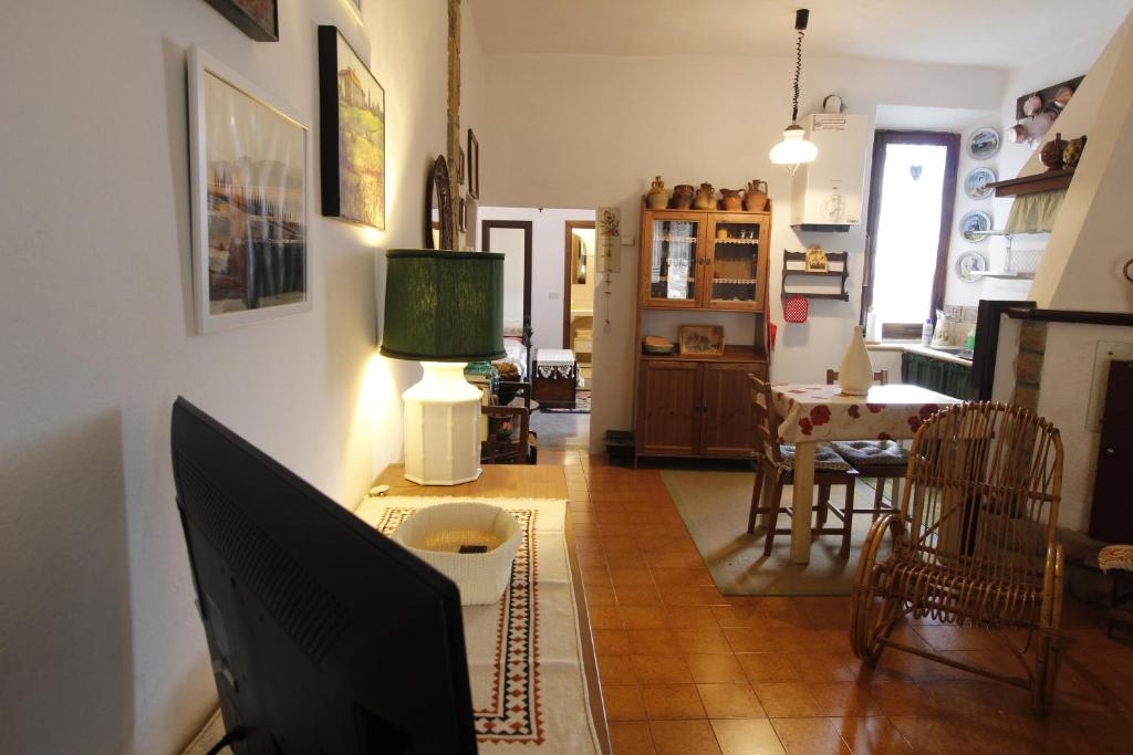 un soggiorno con TV e una sala da pranzo di Casa Isma a Castiglione dʼOrcia