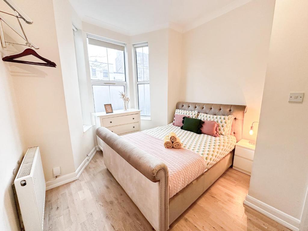 a bedroom with a bed with a teddy bear on it at Charming apartment with a small garden in Finsbury Park in London