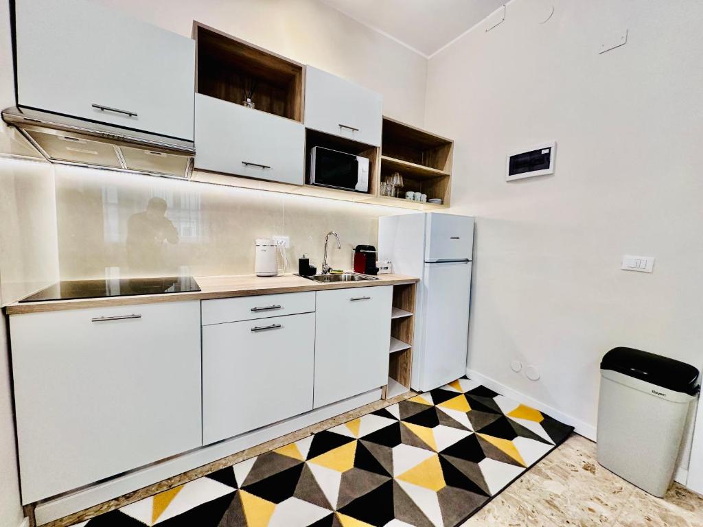 eine Küche mit weißen Schränken und einem karierten Boden in der Unterkunft City life Arsenale in Verona