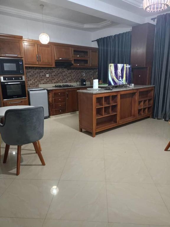 una gran cocina con armarios de madera y una silla en Appartement lumineux, en Kouba