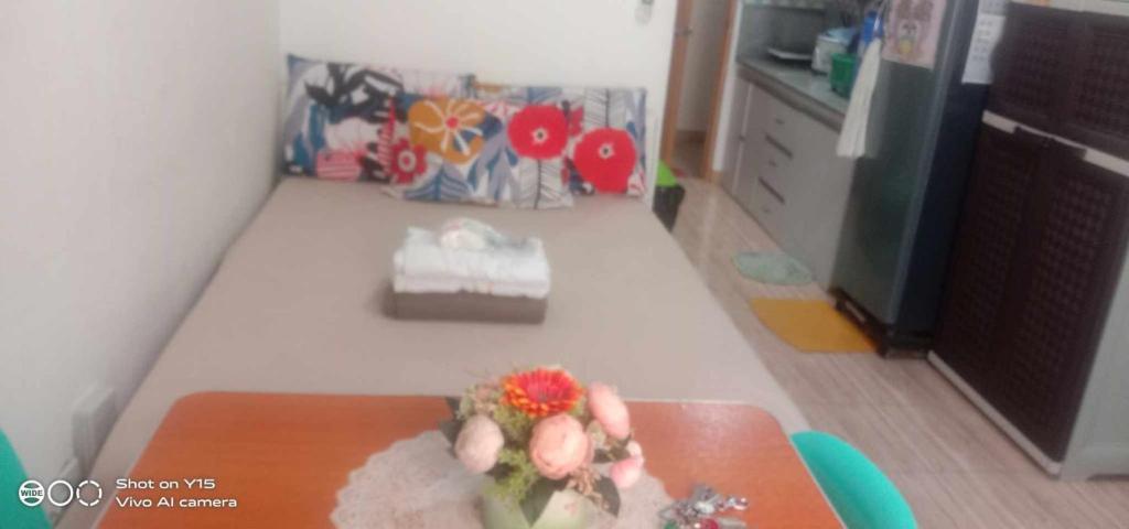 a room with a table with a flower on it at Homey Studio Condo by Malou in Calamba