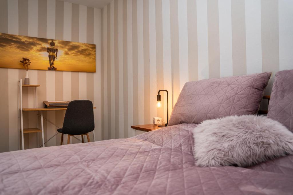1 dormitorio con cama morada y escritorio con lámpara en Ferienwohnung Gold-Blick, en Korbach