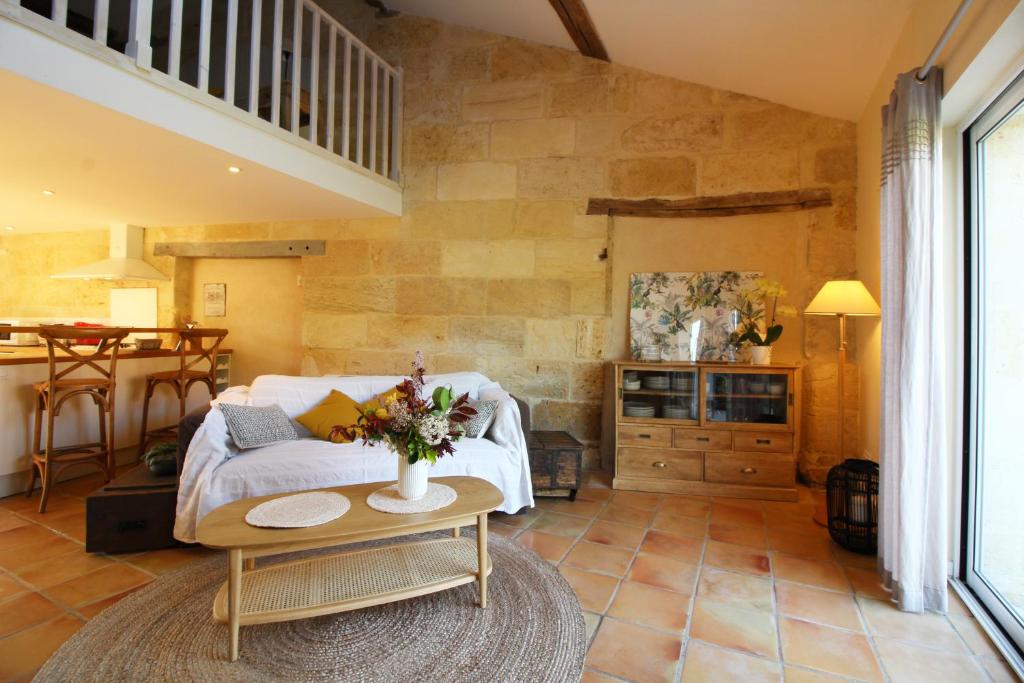 een woonkamer met een bank en een tafel bij Gîte de Fenouil Le Cocon in Civrac-de-Blaye