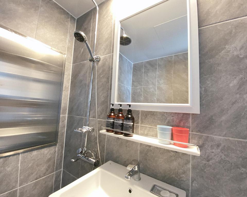 a bathroom with a sink and a shower and a mirror at Gunsan Little Prince Condo in Gunsan-si