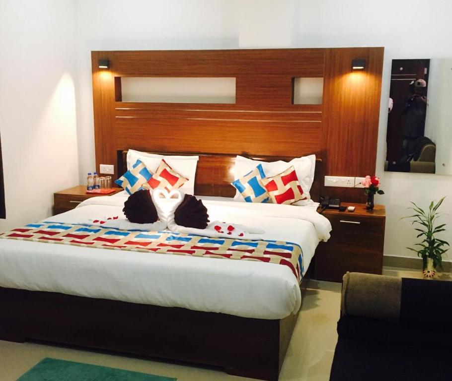 a bedroom with a large bed with a wooden headboard at Rieva Residency in Kottayam