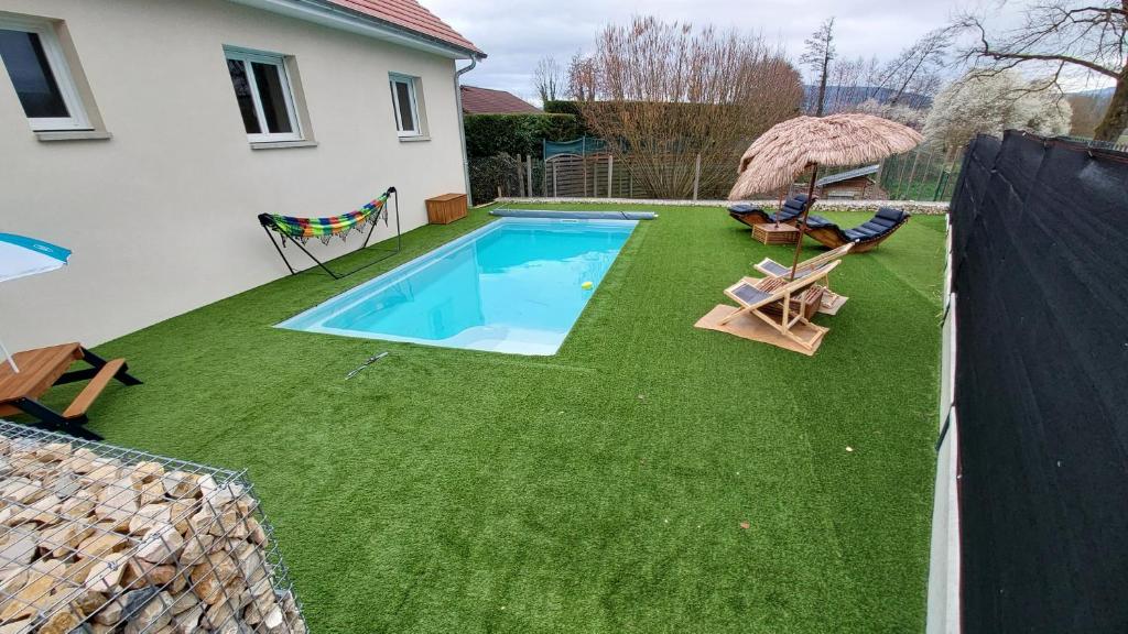 een achtertuin met een zwembad en groen gras bij Maison neuve avec piscine, 10 couchages, tout confort in Granieu