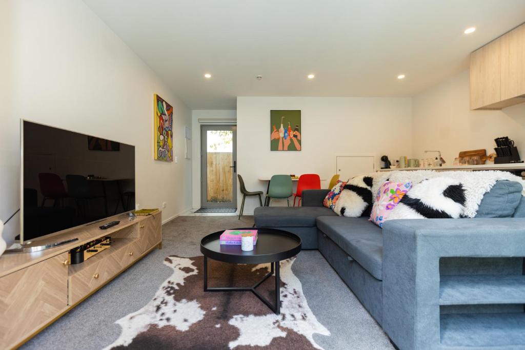 a living room with a blue couch and a tv at stylish and comfort in CBD in Christchurch