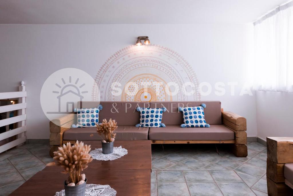 ein Wohnzimmer mit einem braunen Sofa und blauen Kissen in der Unterkunft Be Nature in Porto Cesareo