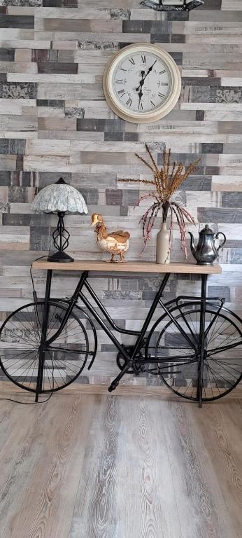 una mesa con una bicicleta con un reloj en la pared en Todea House, en Reghin