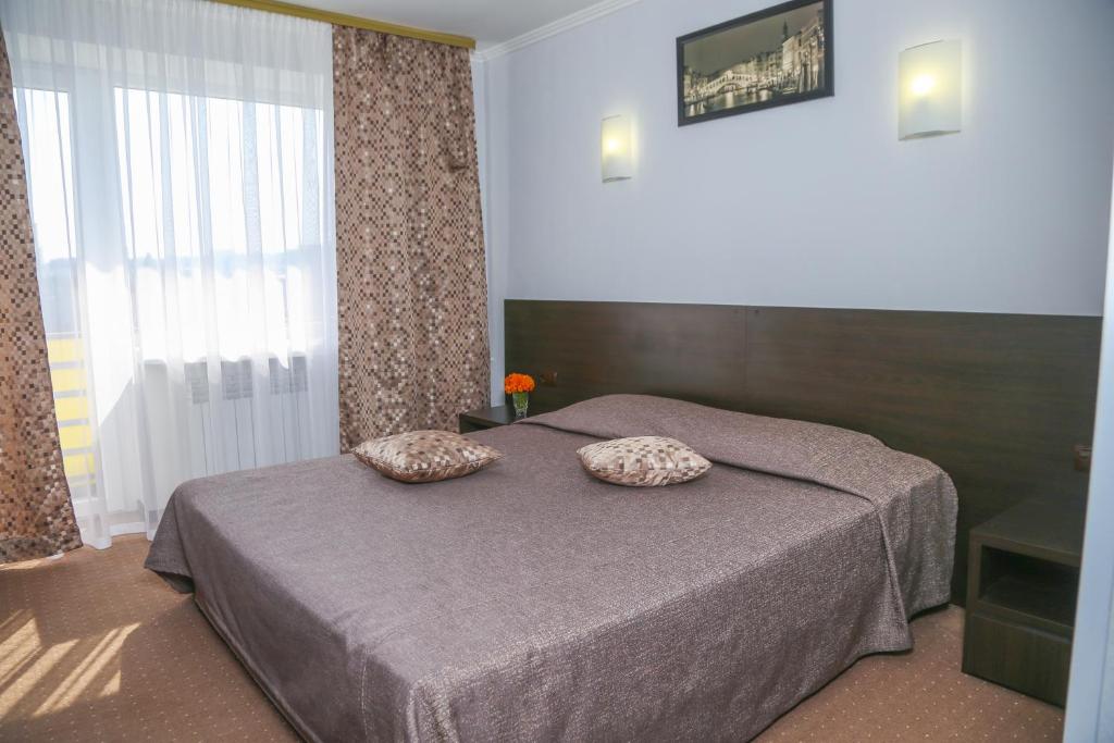 a bedroom with a bed with two pillows on it at Dnepropetrovsk Hotel in Dnipro