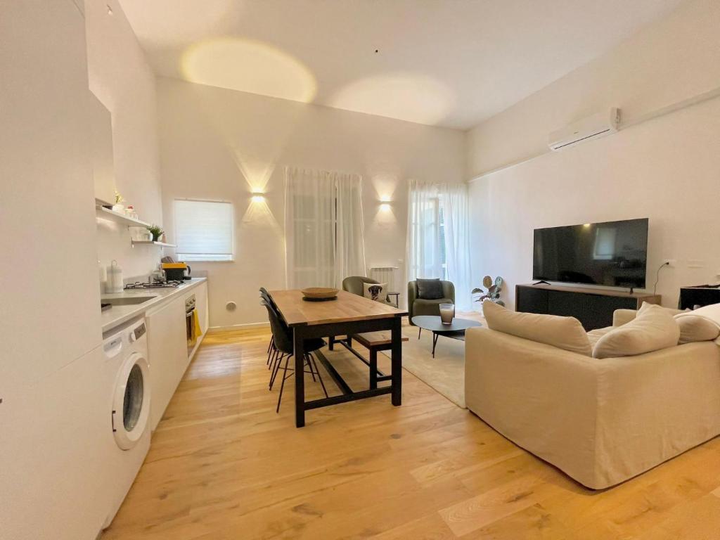 ein Wohnzimmer mit einem Tisch und einem Sofa in der Unterkunft I Marmi New Royal Design Apartment in Livorno