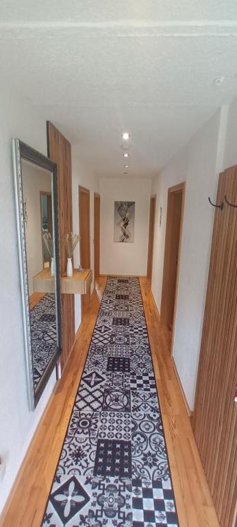 un corridoio con un tappeto bianco e nero sul pavimento di Ferienwohnung Elisabeth Waxweiler a Waxweiler