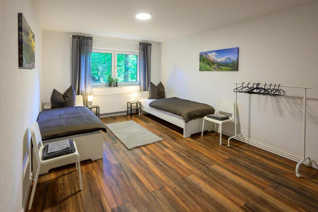 1 dormitorio con 2 camas y ventana en Moderne Ferienwohnung / Monteurswohnung mit 8 Betten in Marburg, en Marburg an der Lahn