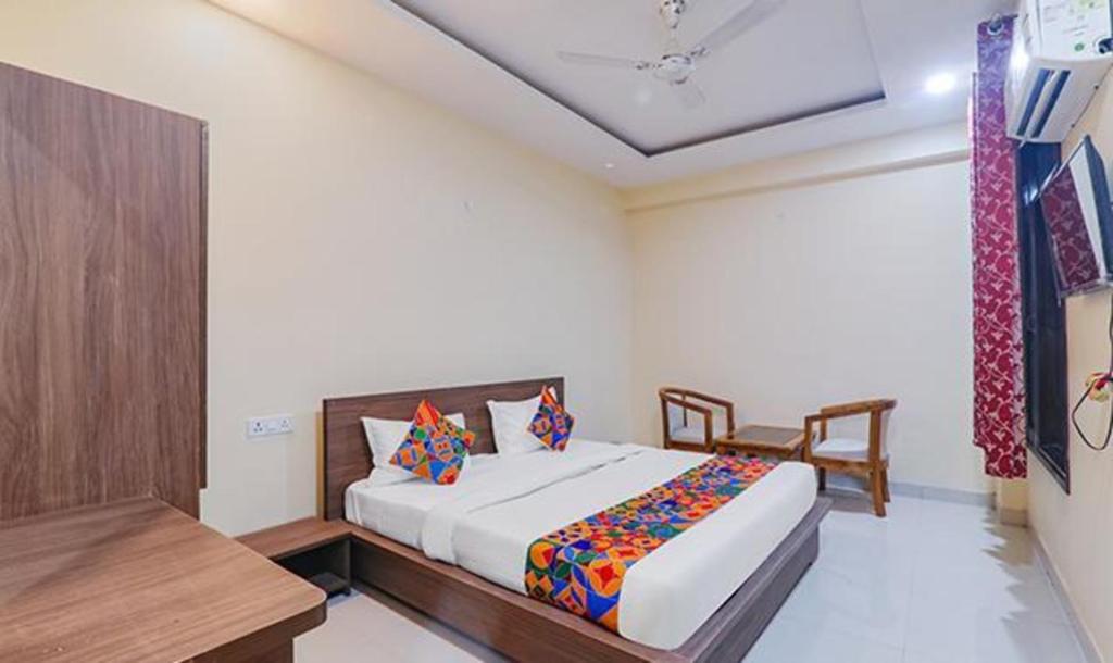 a bedroom with a bed and a desk in it at FabHotel The Gahmar Inn in Lucknow